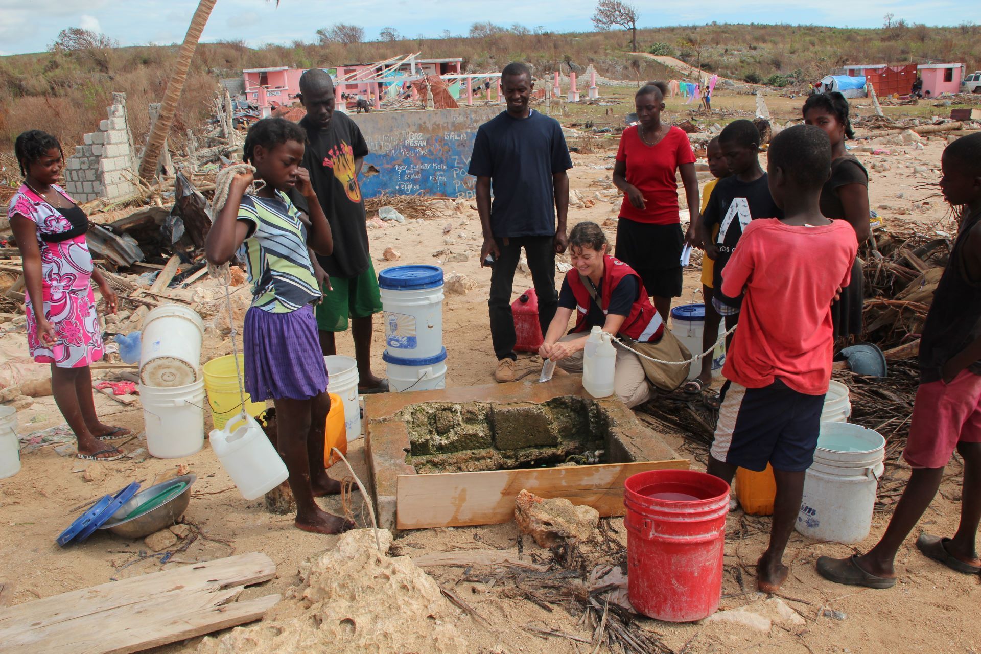 SHA member with Haitian community working with a water laboratory in the field